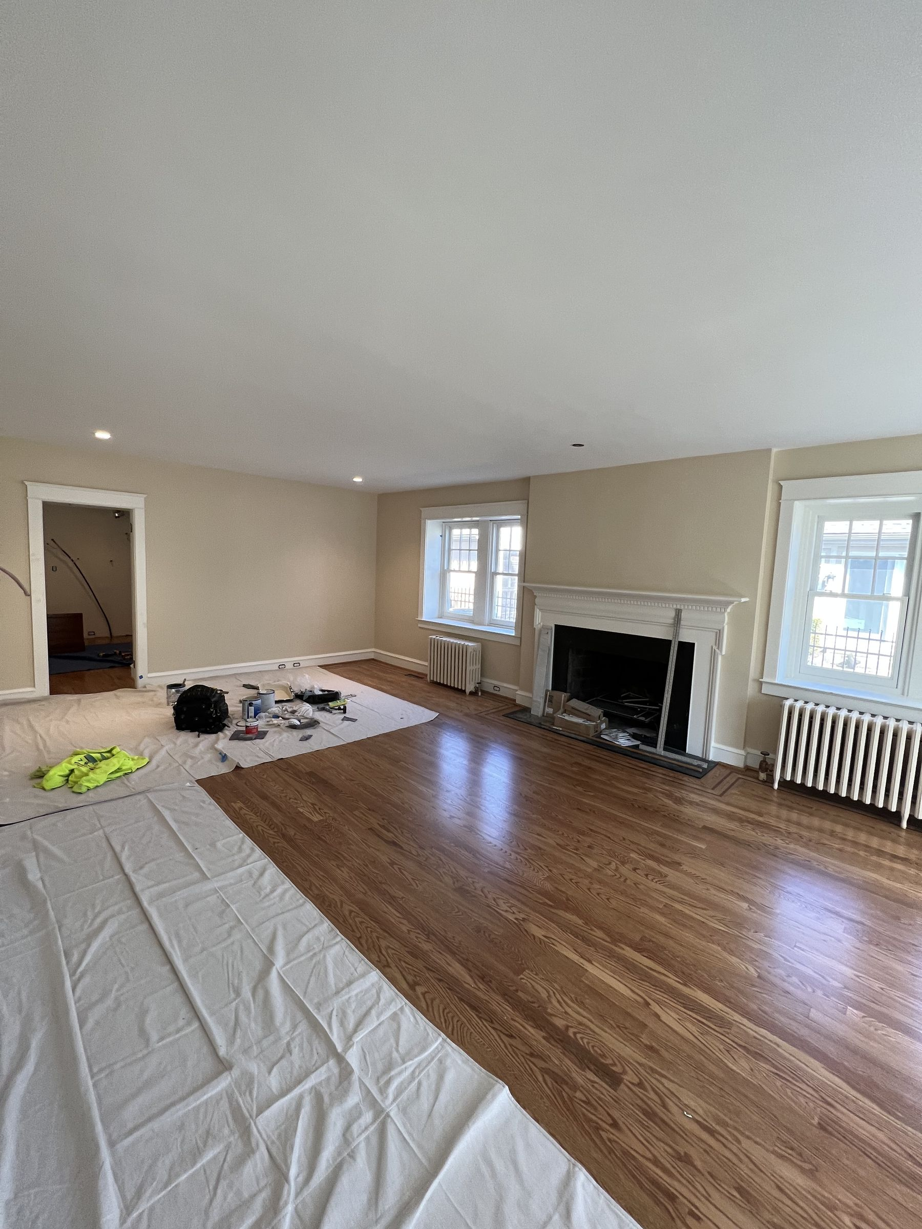 Philadelphia living room during a BrightLight project, with drop cloths protecting the hardwood floors before painting
